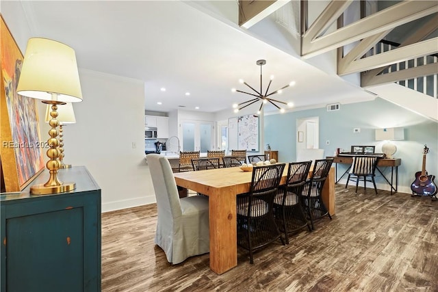 dining room featuring crown molding, hardwood / wood-style floors, and an inviting chandelier