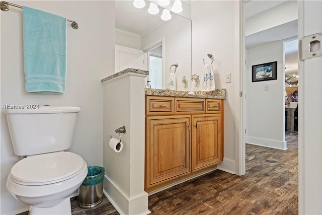 bathroom with hardwood / wood-style flooring, ornamental molding, vanity, and toilet