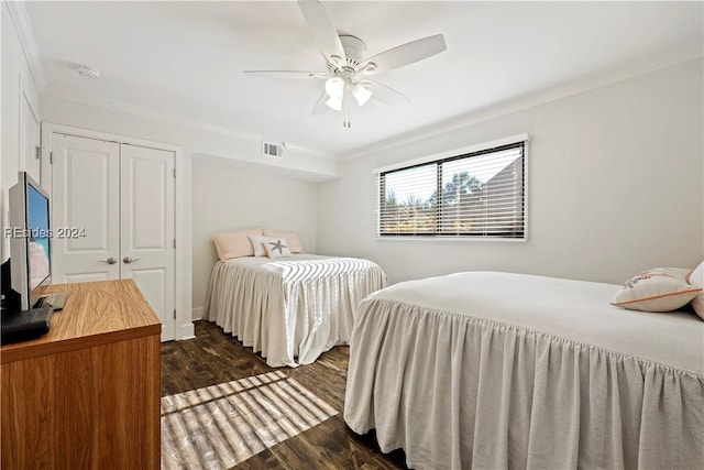 bedroom with ornamental molding, dark hardwood / wood-style floors, ceiling fan, and a closet