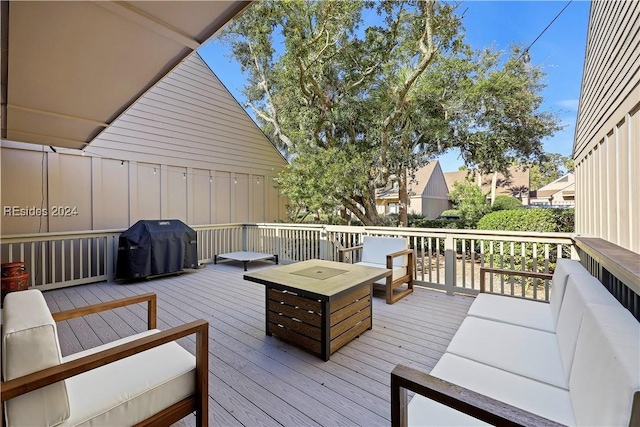 wooden deck featuring area for grilling and an outdoor living space with a fire pit