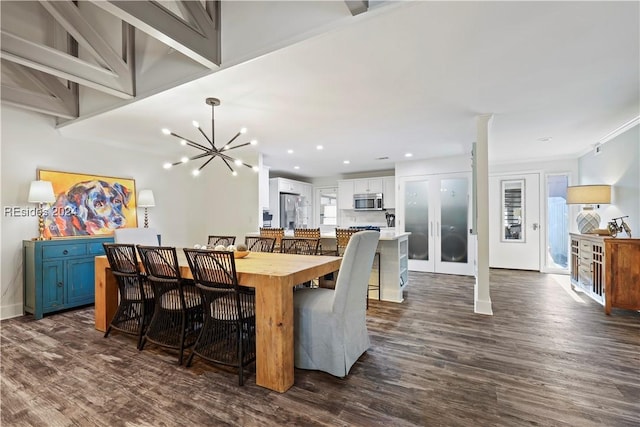 dining room with dark hardwood / wood-style flooring, ornamental molding, and a chandelier