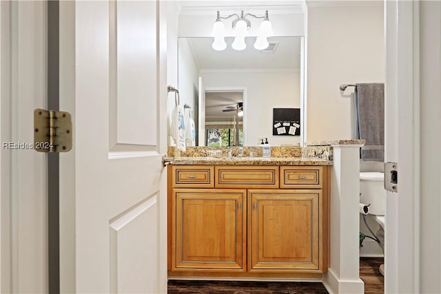 bathroom featuring vanity, crown molding, toilet, and hardwood / wood-style flooring