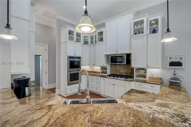 kitchen with white cabinetry, stainless steel appliances, and hanging light fixtures