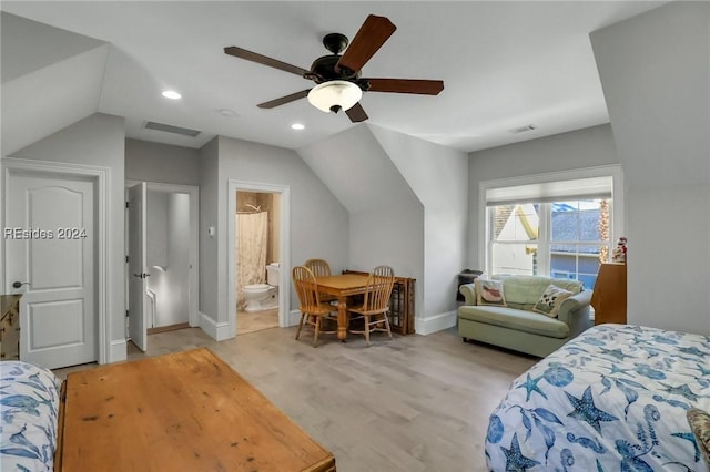 bedroom with ensuite bathroom, lofted ceiling, ceiling fan, and light hardwood / wood-style floors