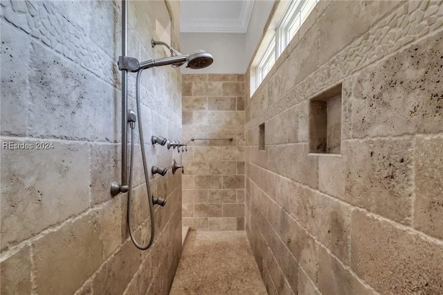 bathroom featuring ornamental molding and a tile shower