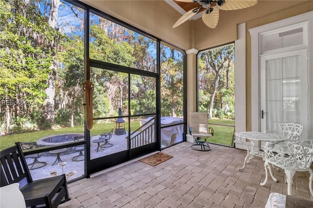 unfurnished sunroom featuring ceiling fan