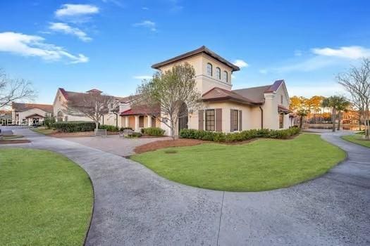 mediterranean / spanish home featuring a front lawn