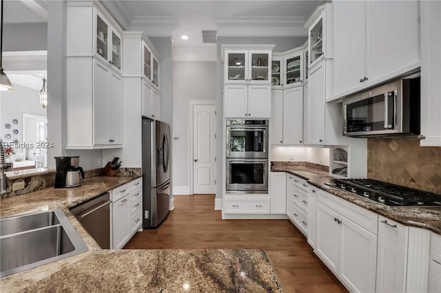 kitchen featuring pendant lighting, appliances with stainless steel finishes, dark stone countertops, and white cabinets