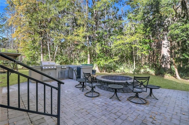 view of patio / terrace featuring a grill, exterior kitchen, and an outdoor fire pit