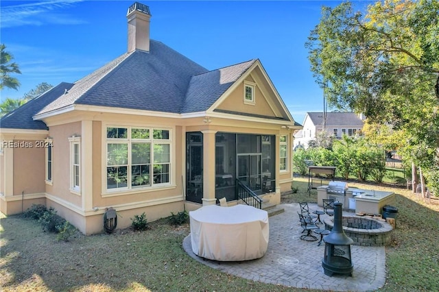 back of property with a fire pit, a sunroom, and a patio