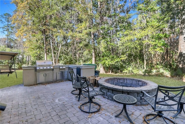 view of patio featuring a grill, an outdoor fire pit, and exterior kitchen