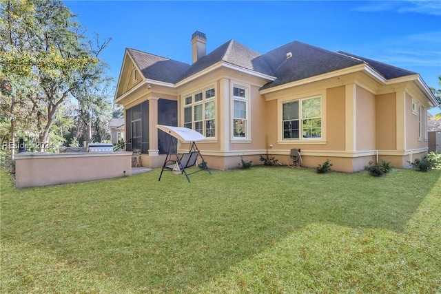 rear view of property with a yard and a sunroom