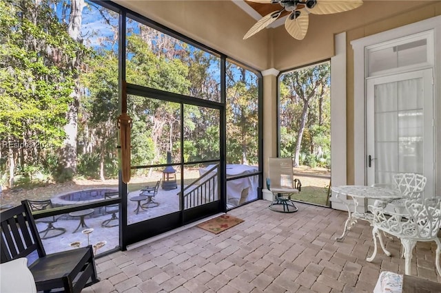 unfurnished sunroom featuring ceiling fan