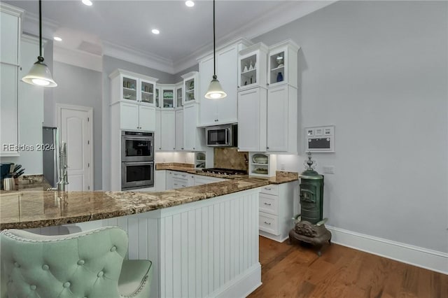 kitchen featuring stainless steel appliances, hanging light fixtures, stone counters, and kitchen peninsula