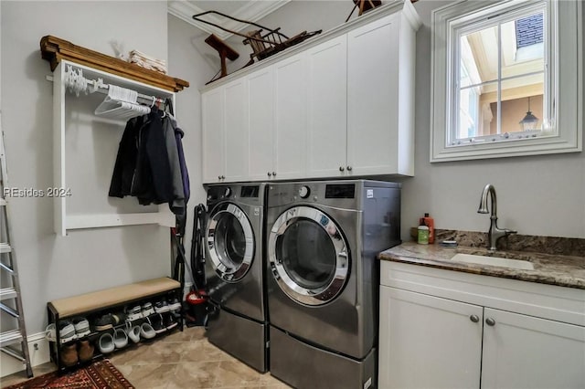 clothes washing area with sink, cabinets, and washing machine and clothes dryer