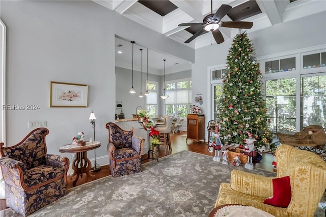 living area featuring beamed ceiling, ceiling fan, ornamental molding, and coffered ceiling