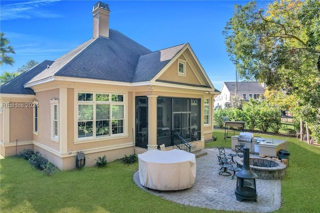 back of property with a sunroom, a yard, a patio area, and an outdoor fire pit