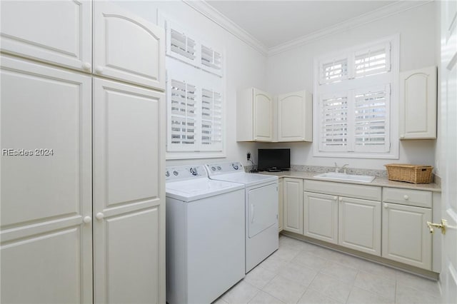 clothes washing area with sink, crown molding, cabinets, light tile patterned floors, and washing machine and dryer