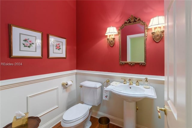 bathroom featuring hardwood / wood-style flooring and toilet