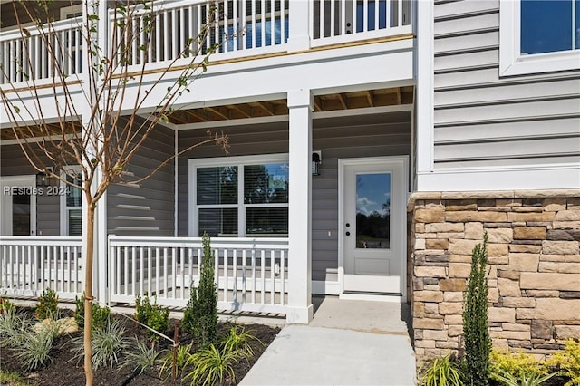 view of exterior entry with a balcony