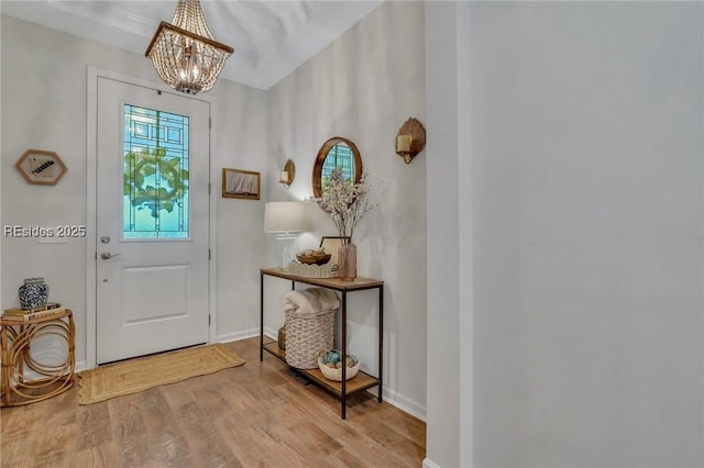 doorway with a chandelier and light wood-type flooring