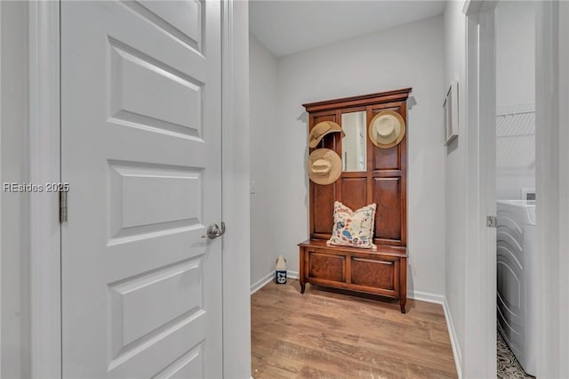 hallway featuring washer / dryer and light hardwood / wood-style floors