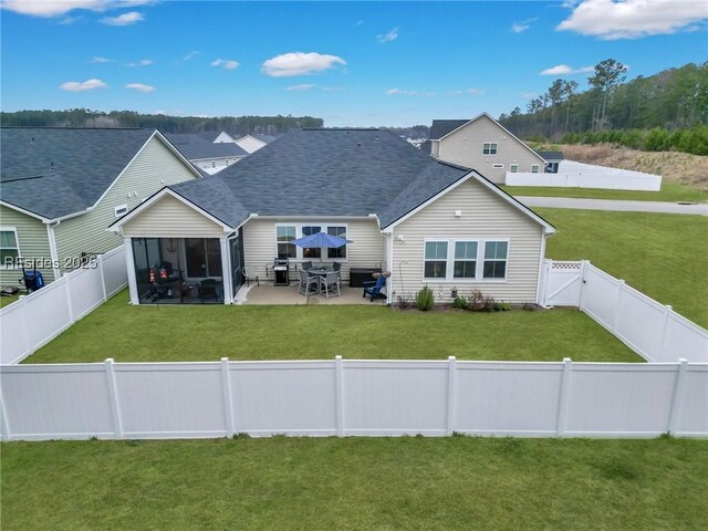 back of property featuring a yard, a sunroom, and a patio