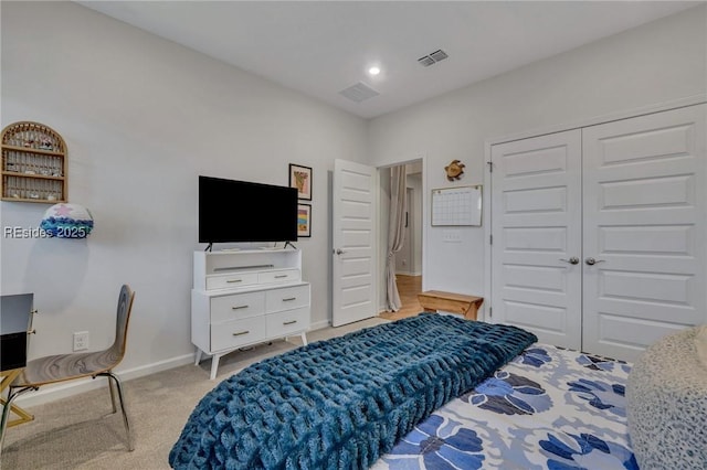 bedroom featuring light colored carpet and a closet