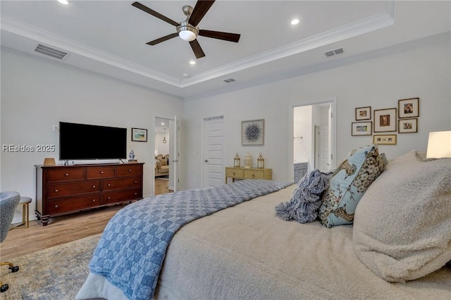 bedroom featuring a raised ceiling, crown molding, connected bathroom, and ceiling fan