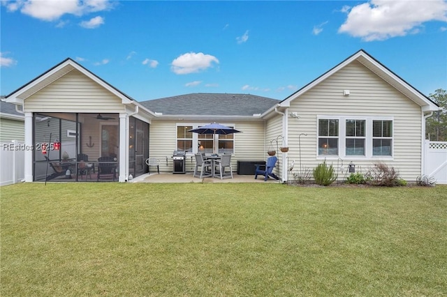 rear view of property with a patio, a sunroom, and a lawn