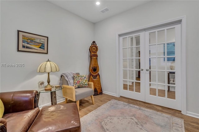 sitting room with hardwood / wood-style flooring and french doors