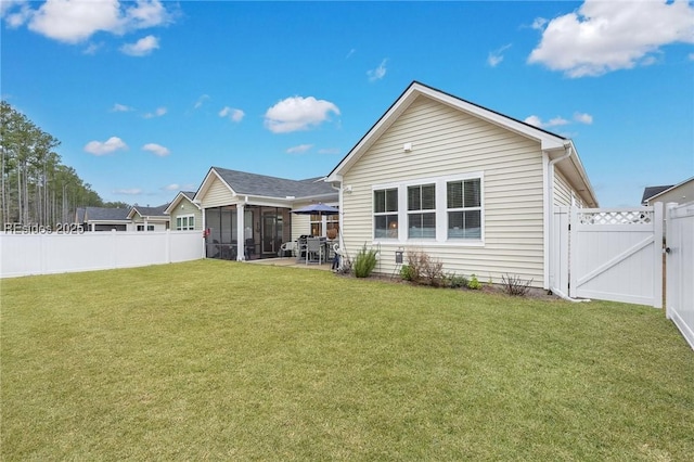 rear view of property with a yard, a sunroom, and a patio area