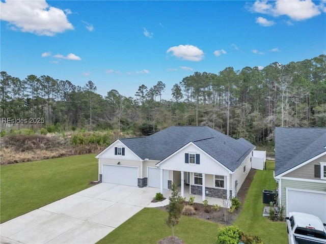 view of front of property featuring cooling unit, a garage, a front yard, and covered porch