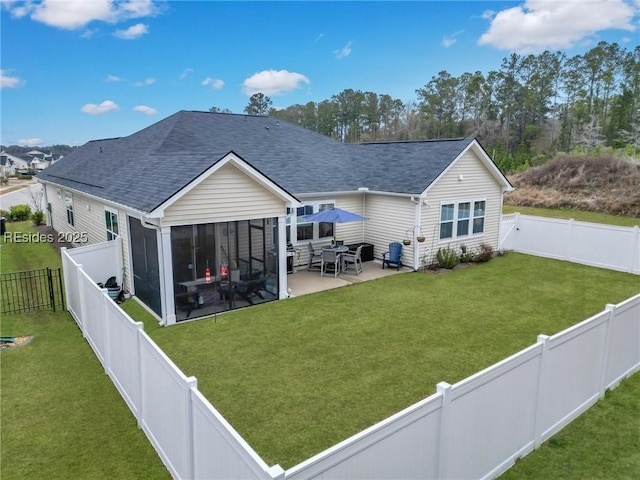 rear view of property with a sunroom, a patio area, and a lawn