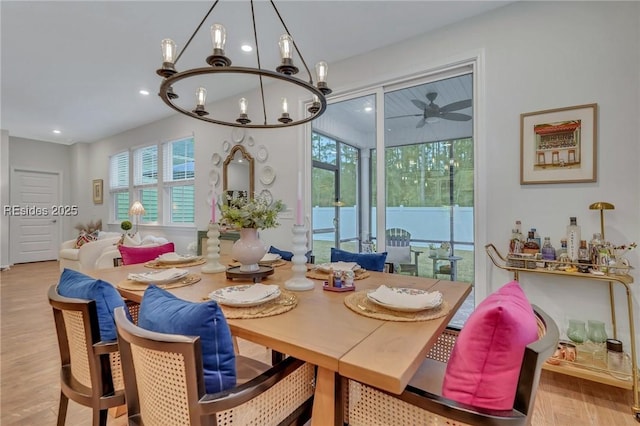 dining area featuring ceiling fan with notable chandelier and light hardwood / wood-style flooring