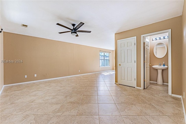 tiled empty room featuring ceiling fan