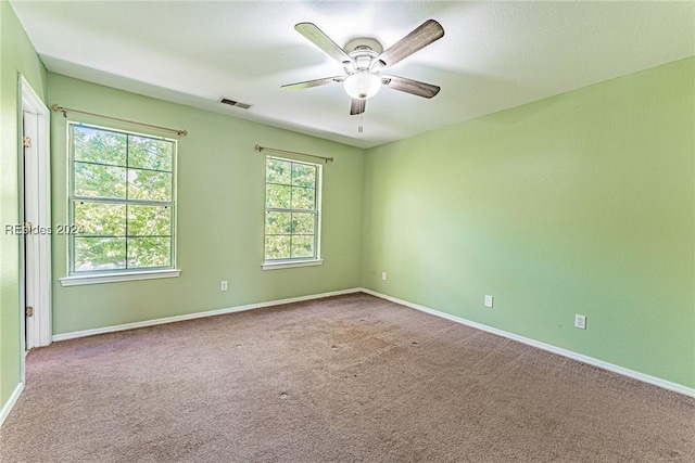 unfurnished room with light colored carpet and ceiling fan