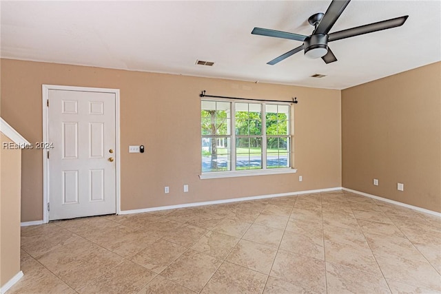 tiled spare room featuring ceiling fan