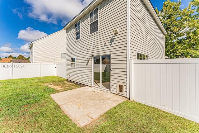 back of property featuring a patio and a lawn