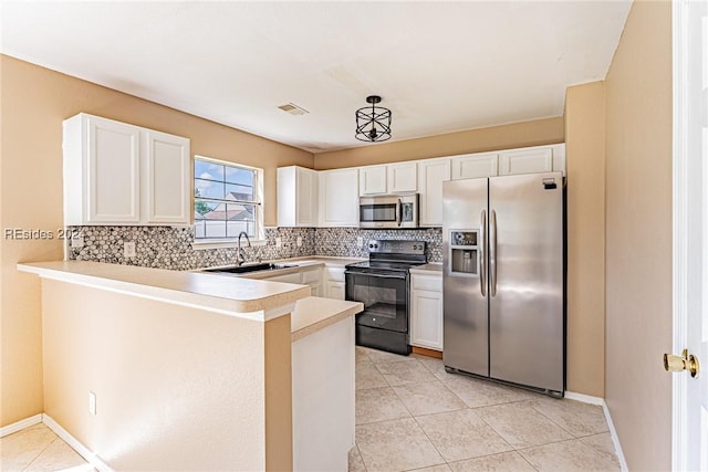 kitchen with pendant lighting, sink, appliances with stainless steel finishes, white cabinets, and kitchen peninsula