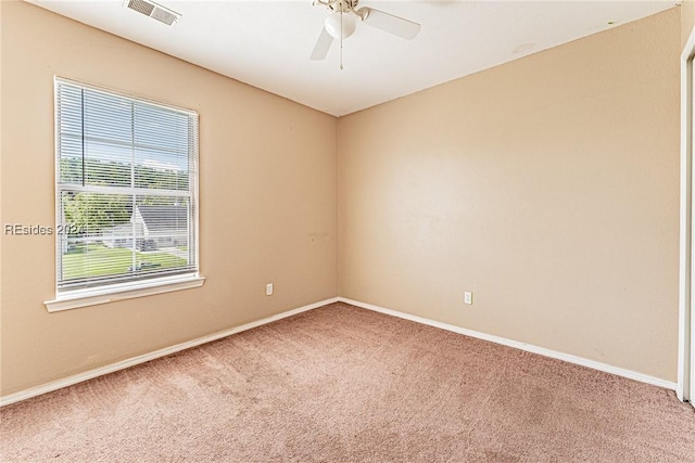 carpeted spare room featuring ceiling fan