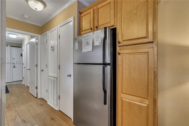 kitchen featuring ornamental molding, light brown cabinets, and stainless steel refrigerator