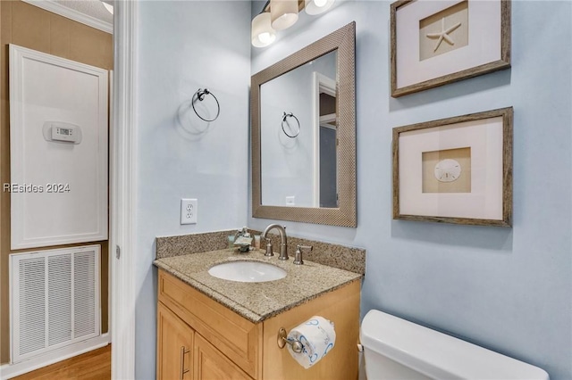 bathroom featuring ornamental molding, toilet, and vanity