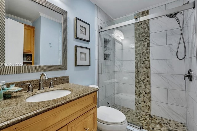 bathroom with vanity, ornamental molding, toilet, and walk in shower