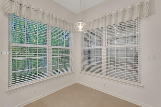 tiled spare room with a healthy amount of sunlight