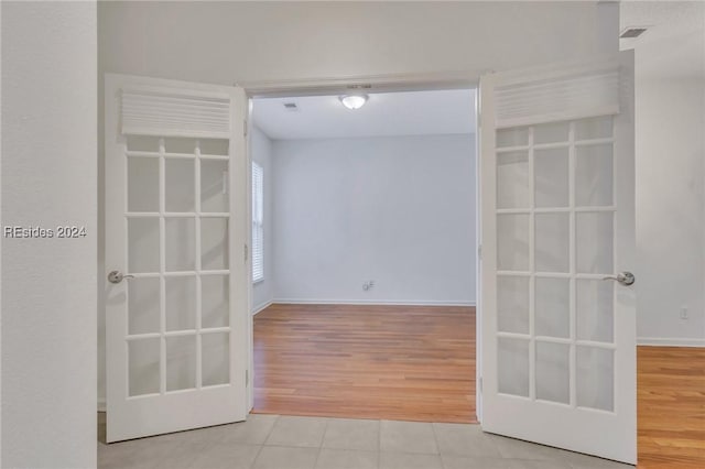 tiled empty room featuring french doors