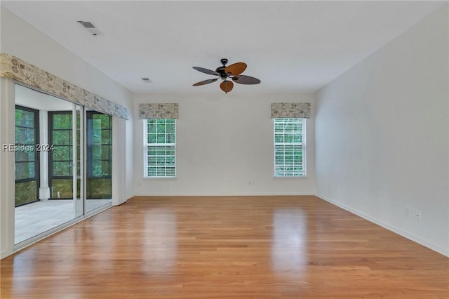 unfurnished room with ceiling fan, a wealth of natural light, and light wood-type flooring