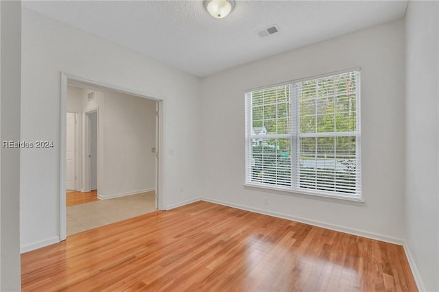 unfurnished room featuring hardwood / wood-style flooring and a textured ceiling