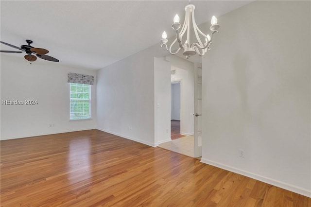 unfurnished room featuring ceiling fan with notable chandelier and light hardwood / wood-style floors