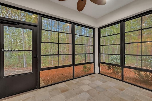 unfurnished sunroom with ceiling fan